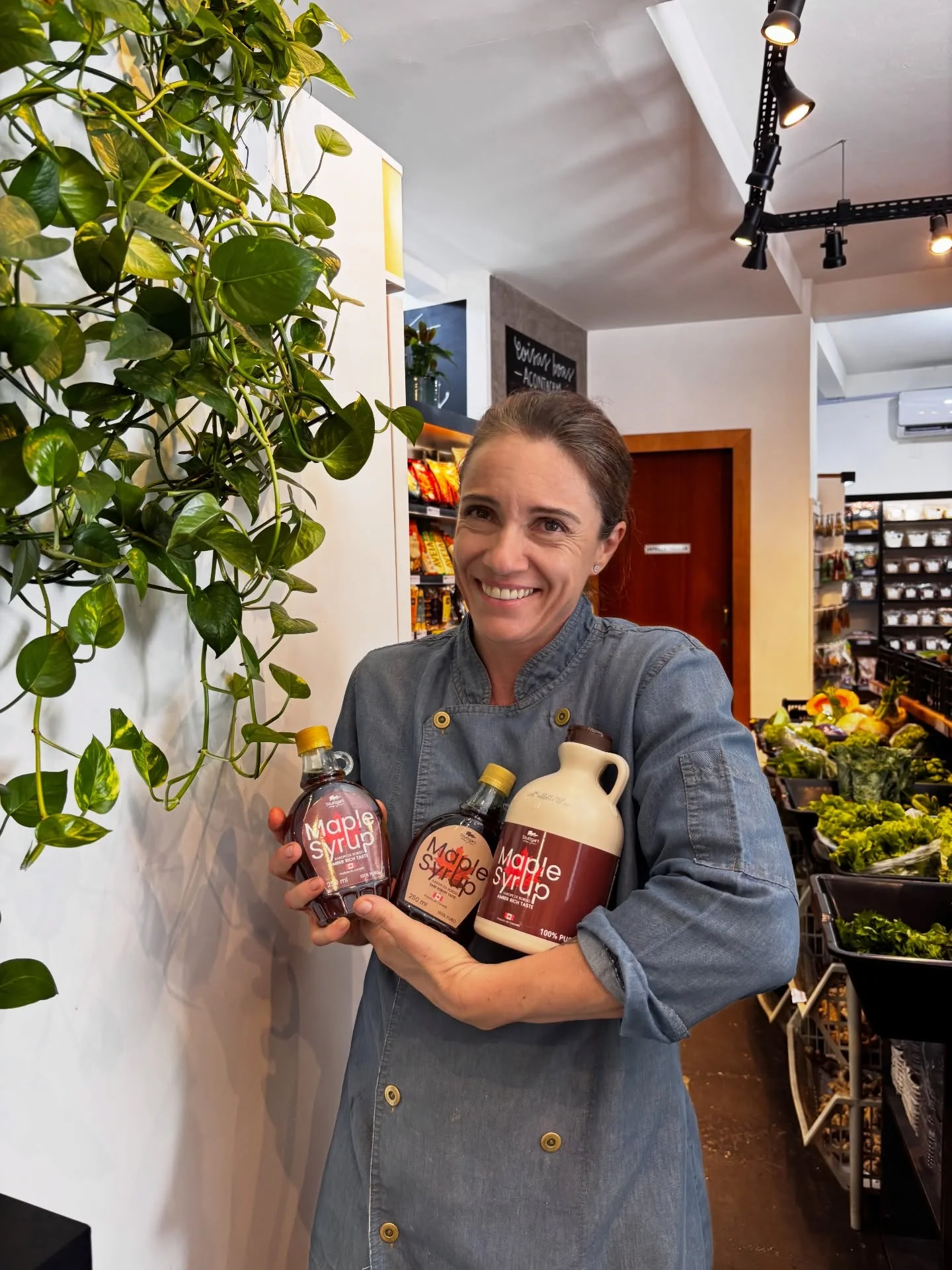 Lia Toss segurando maple syrup orgânico — curadoria de produtos selecionados no Emporium