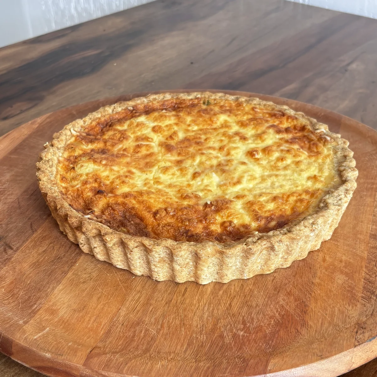 Quiches artesanais Lia Toss servidas em tábua de madeira