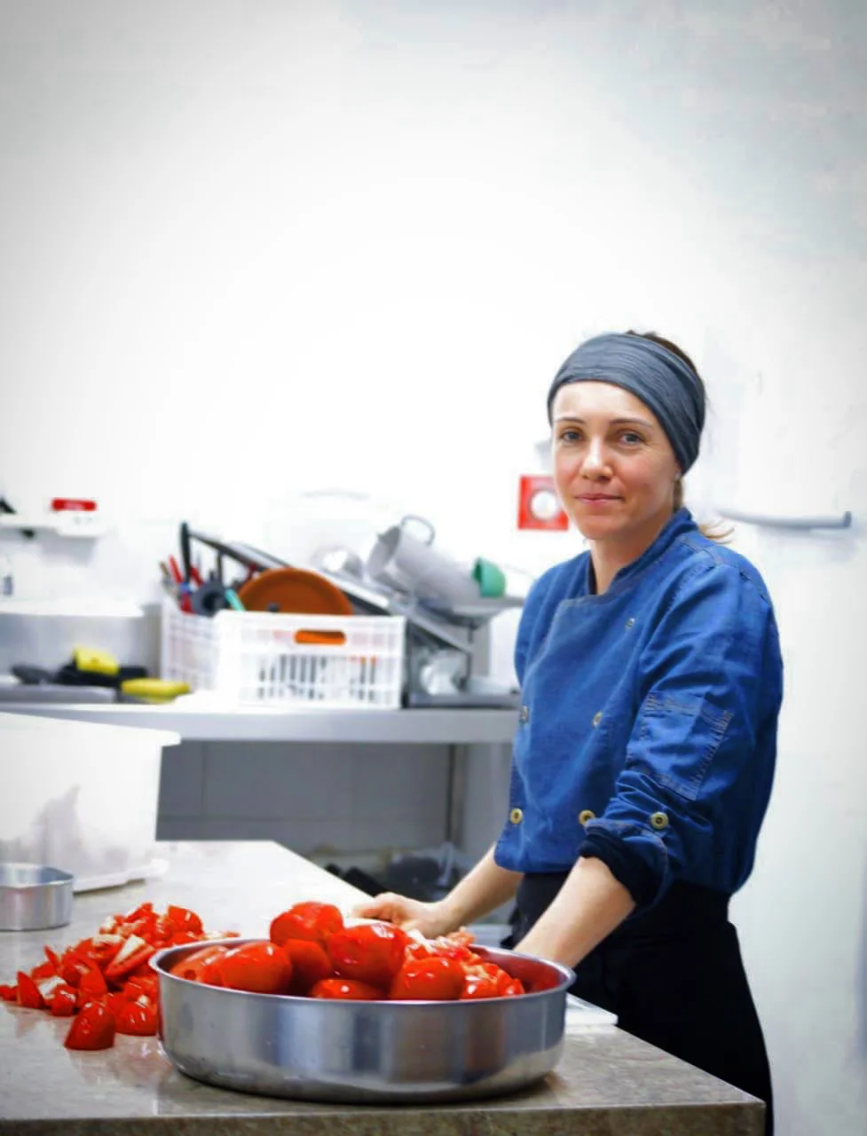 Lia Toss preparando tomates orgânicos na cozinha de fabricação própria